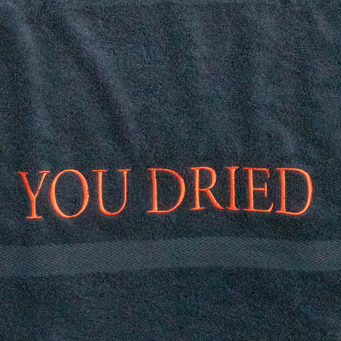 Close-up van de rood geborduurde "YOU DRIED" letters