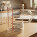 Messbecher Wissenschaft aus Glas auf einer Holz-Arbeitsplatte im Kuechen-/Laborambiente